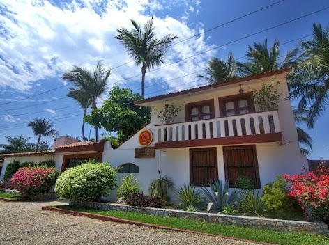 Villa María exterior with palm trees and bougainvillea